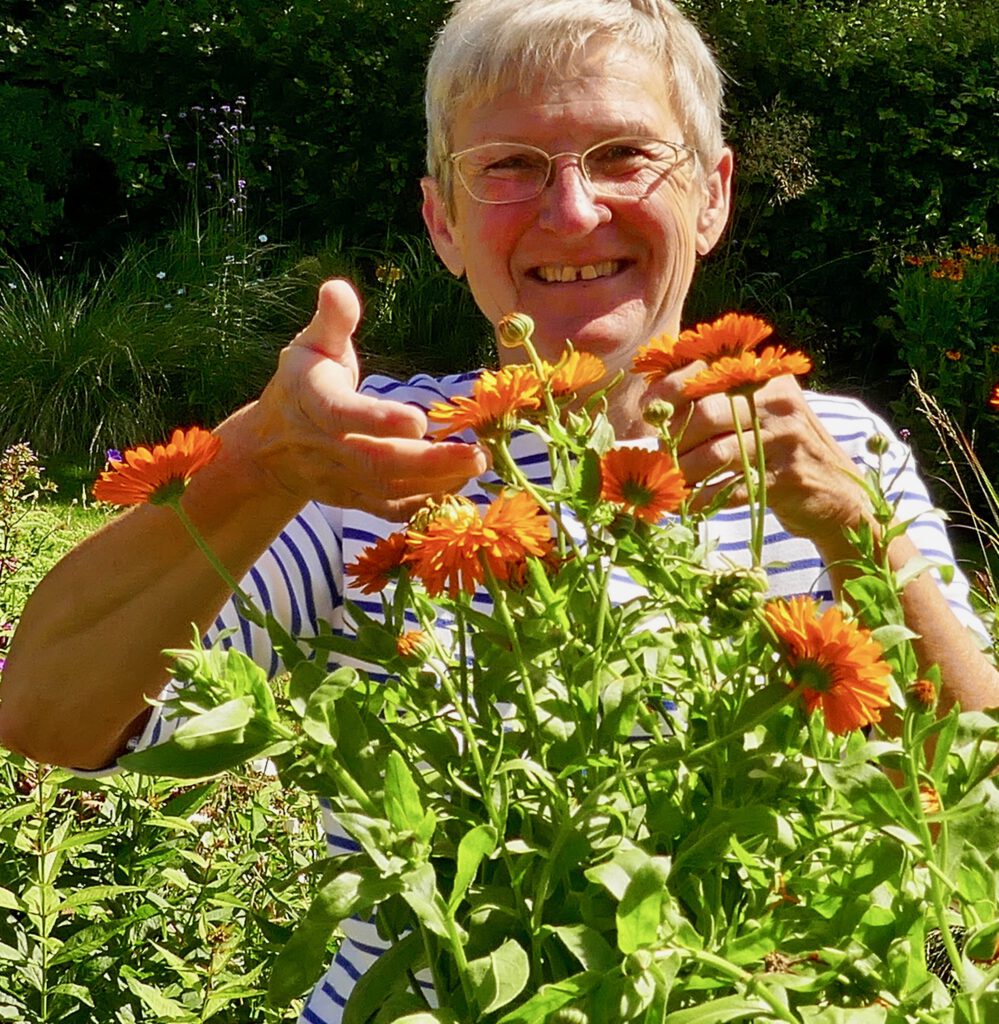 Brigitte Dammann im Garten mit Ringelblumenblüten